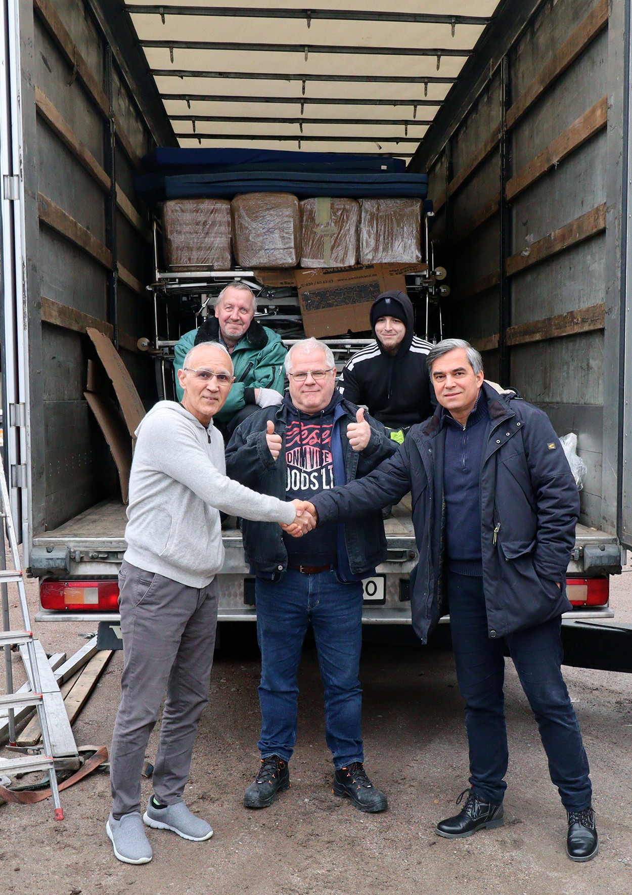 Einer der Geschäftsführer und ein Mitarbeiter übergeben die Hilfsgüter an die Abholer aus der Ukraine.