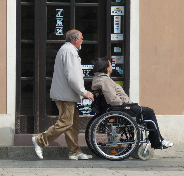 Eine Rollstuhlfahrerin wird beim täglichen Einkauf unterstützt.